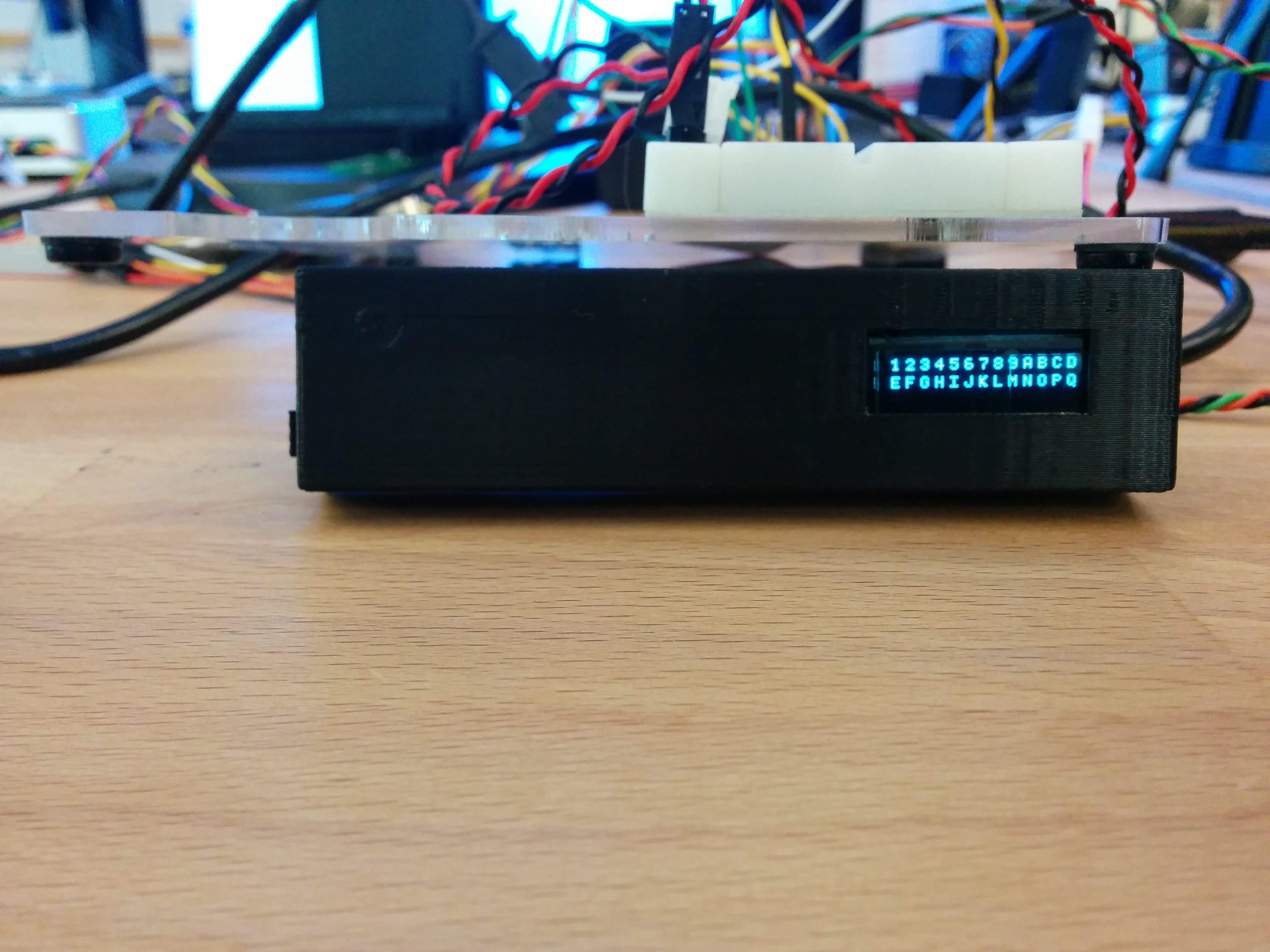 Custom OLED node ID display that fits within 3.5 inch bay. Shown with 3D printed cover. Text on OLED shows alphabet printed on two lines.