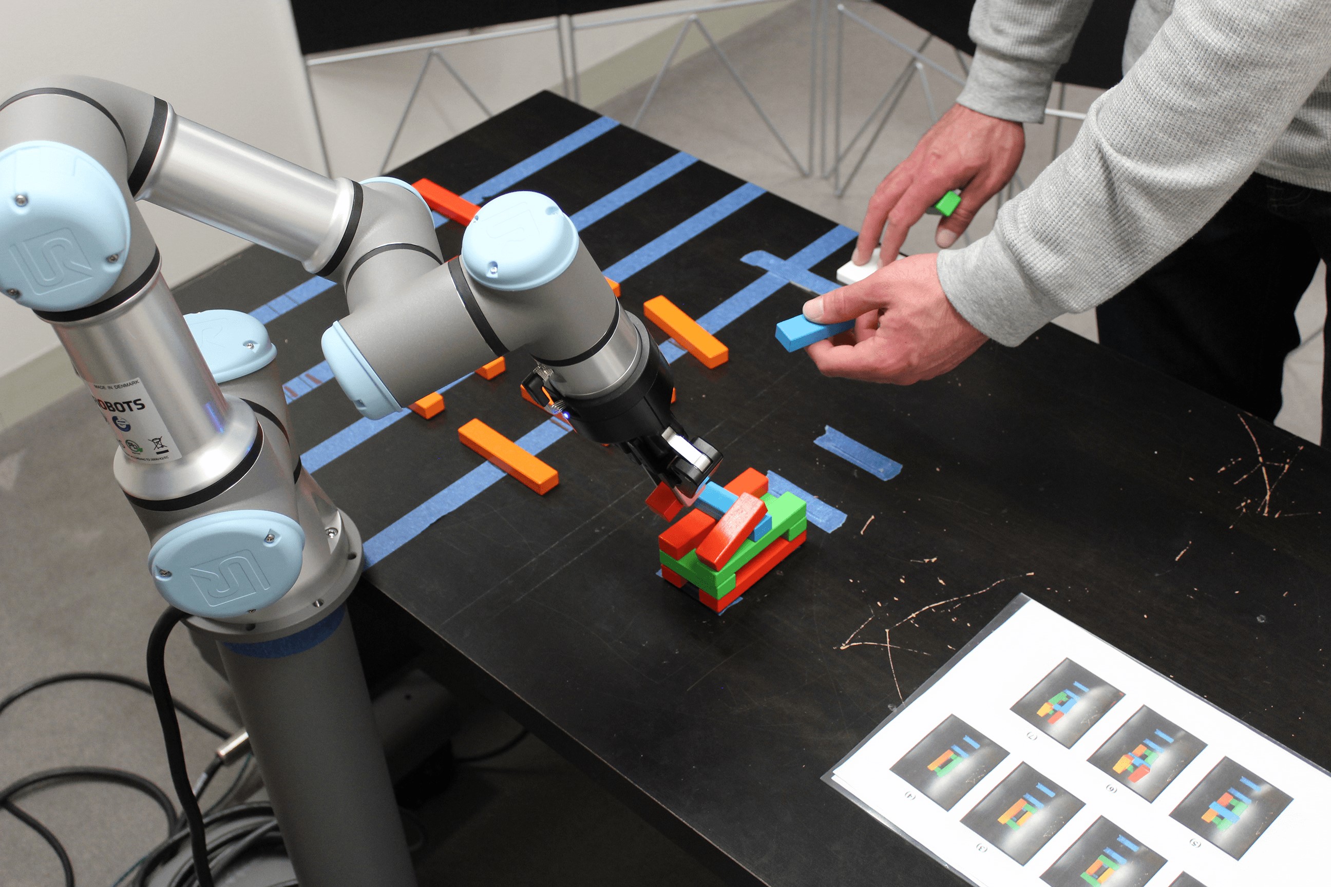 Participant constructs wooden block structure with the robot.